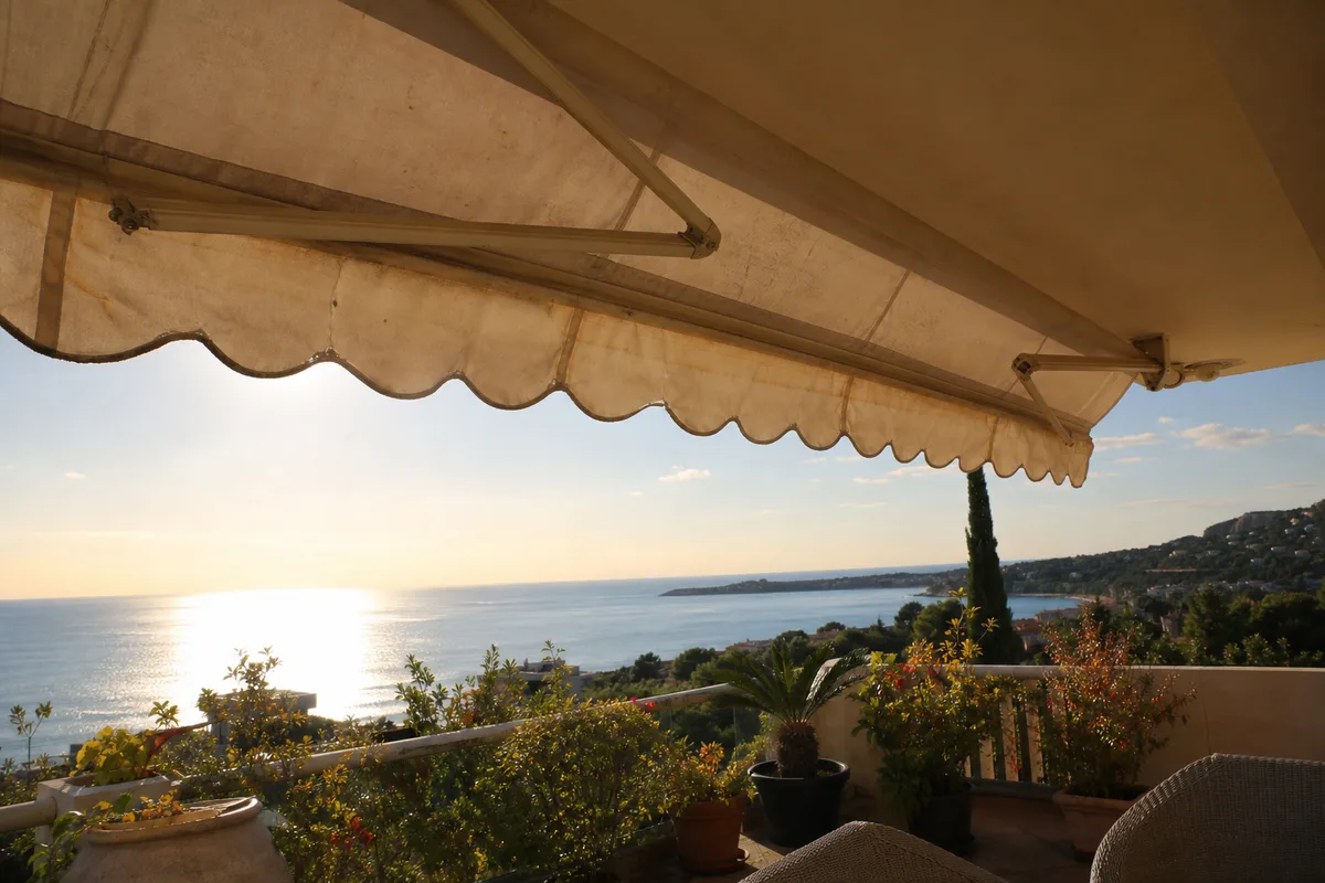 Store banne deroule sur une terrasse ensoleillee face a la mer sur la Cote d&rsquo;Azur