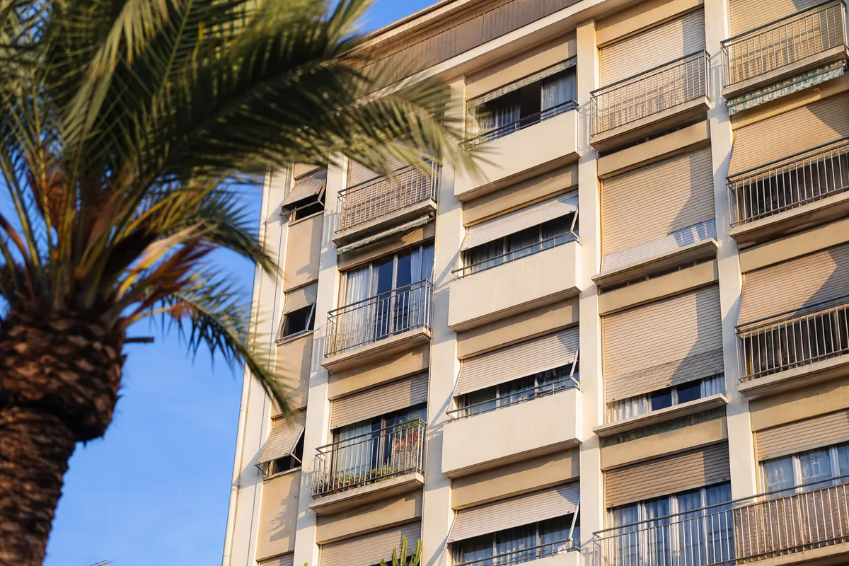 Volets roulants aluminium sur la façade d&rsquo;un immeuble méditerranéen ensoleillé
